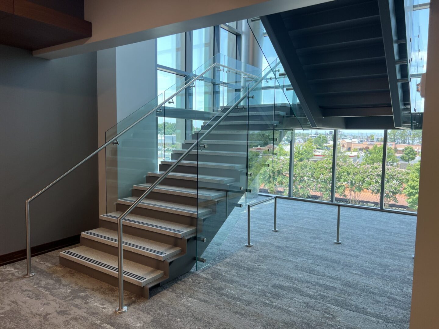 A white staircase with glass and metal handrails