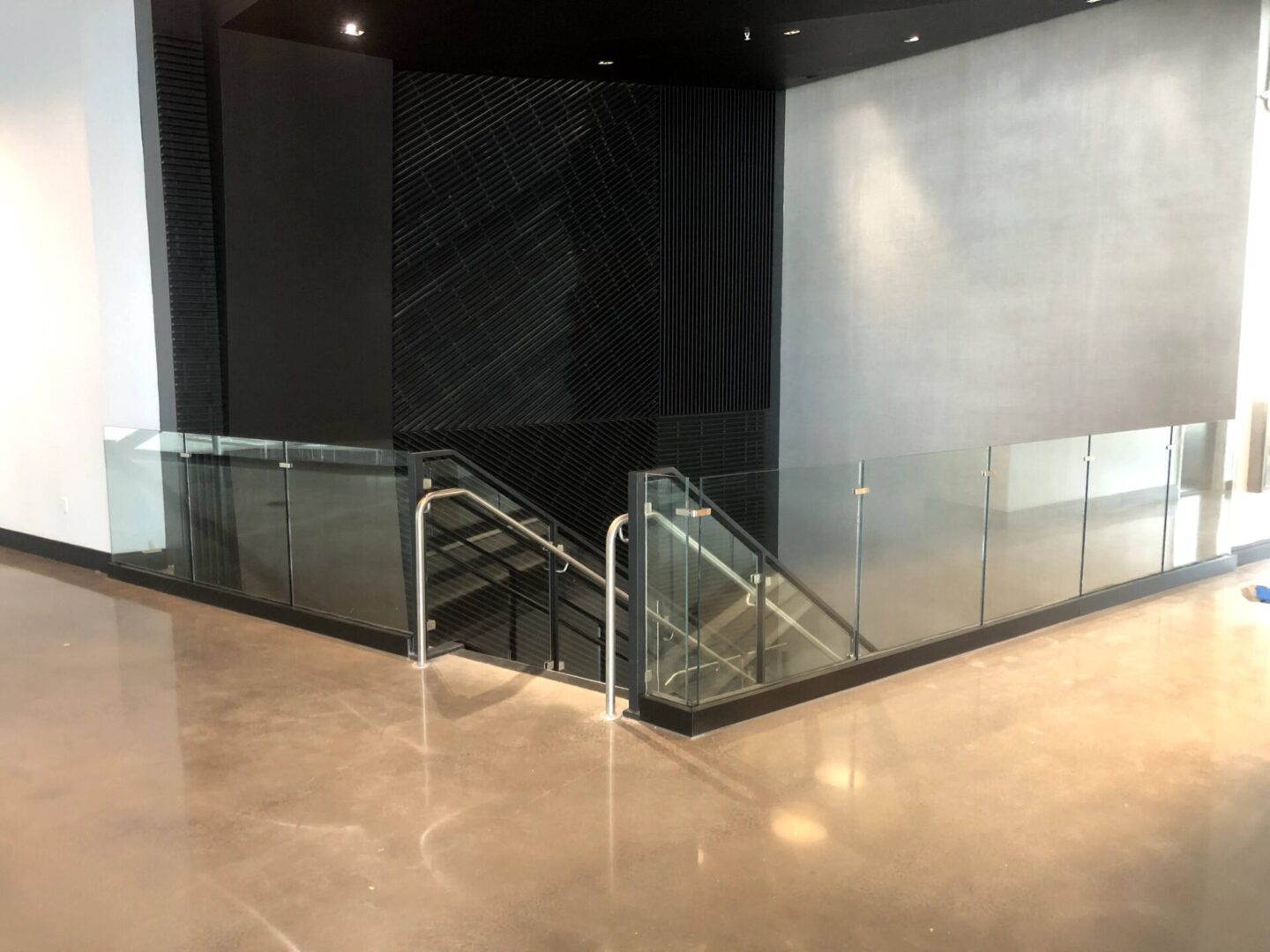 A staircase with glass handrails and metal frame