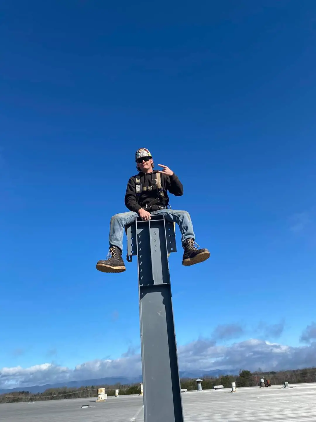 A man sitting on top of a steel beam